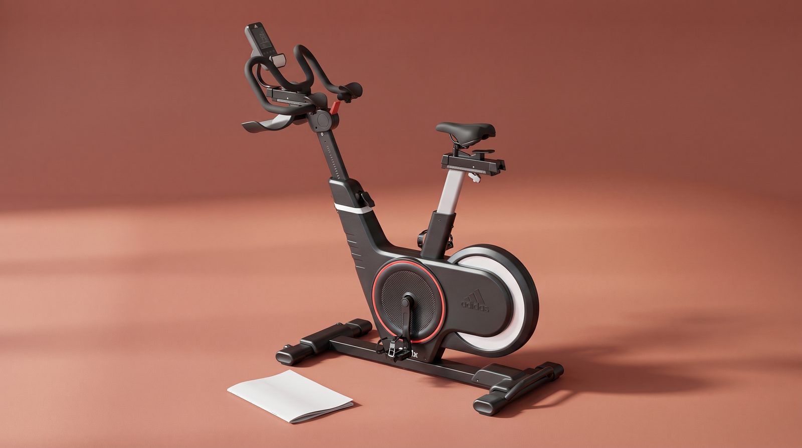 The referenced Adidas C-21x exercise bike beside a blank assembly booklet.