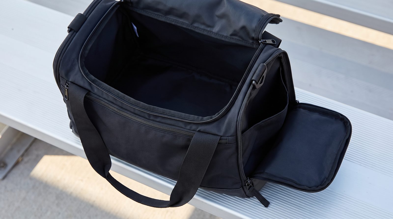 An unbranded duffel bag with its main opening and separate end compartment visible.