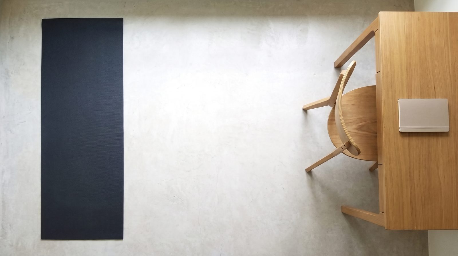 An exercise mat with a clear gap separating it from a desk and chair.