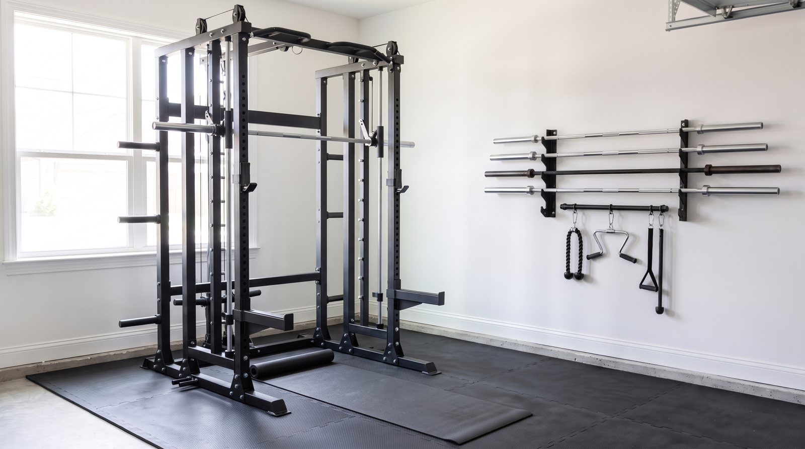 A garage exercise area with a rack, mat and clear access space.