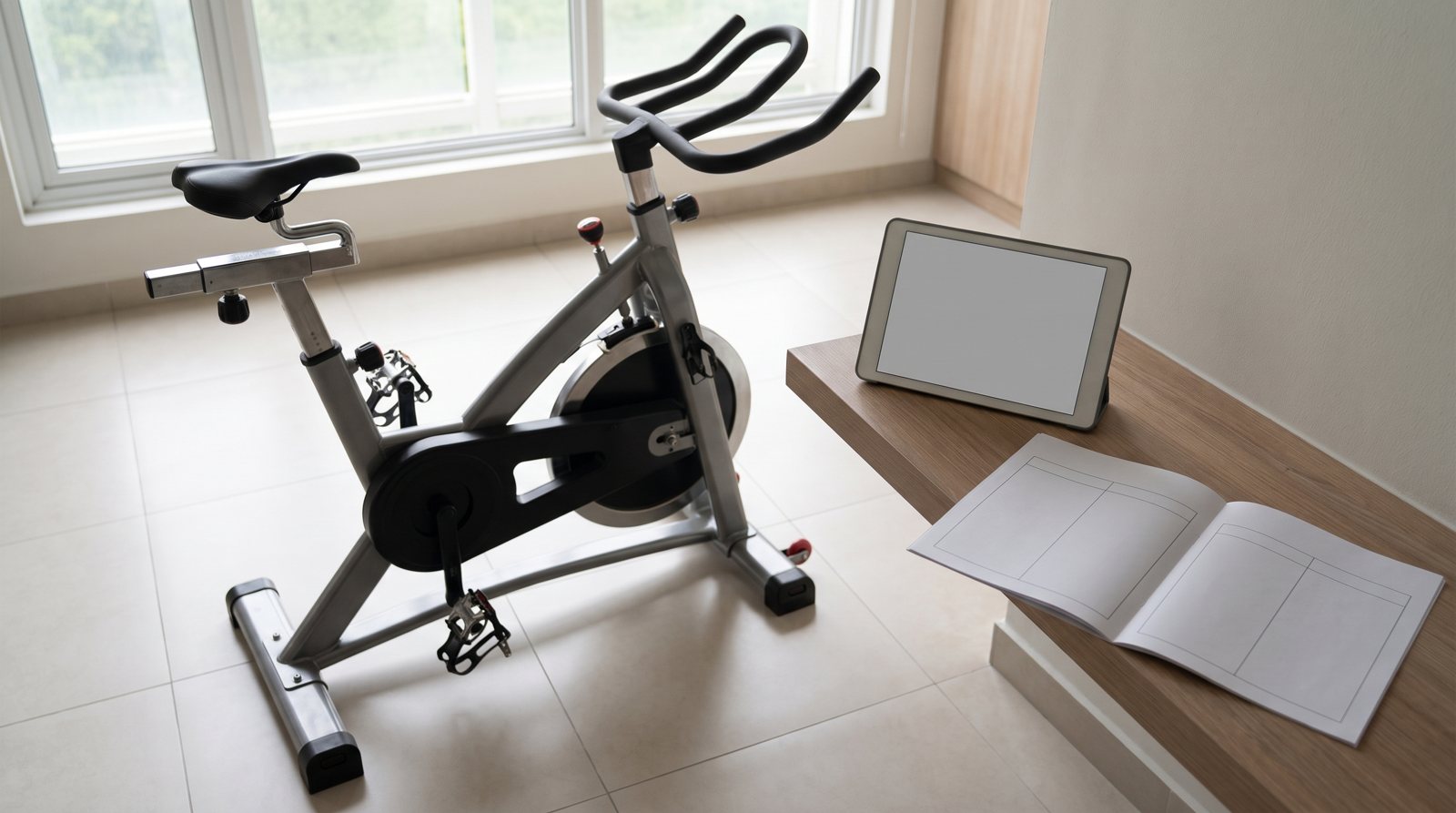 An indoor bike beside a blank screen and comparison worksheet.