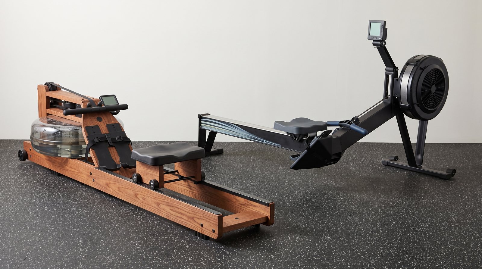 A rowing machine with a transparent water tank beside one with an air-fan housing.